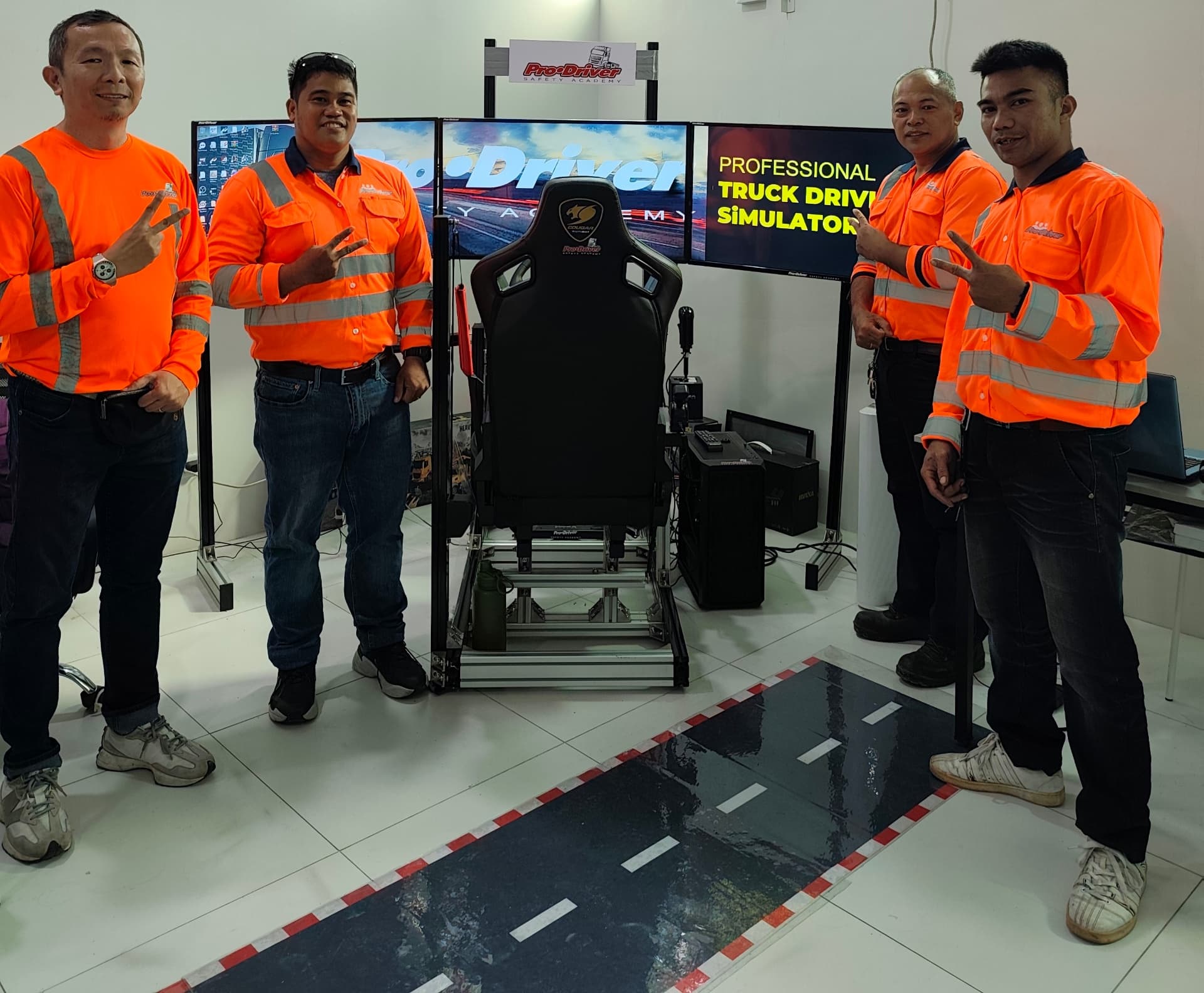 PDSA instructors beside the professional truck driving simulator